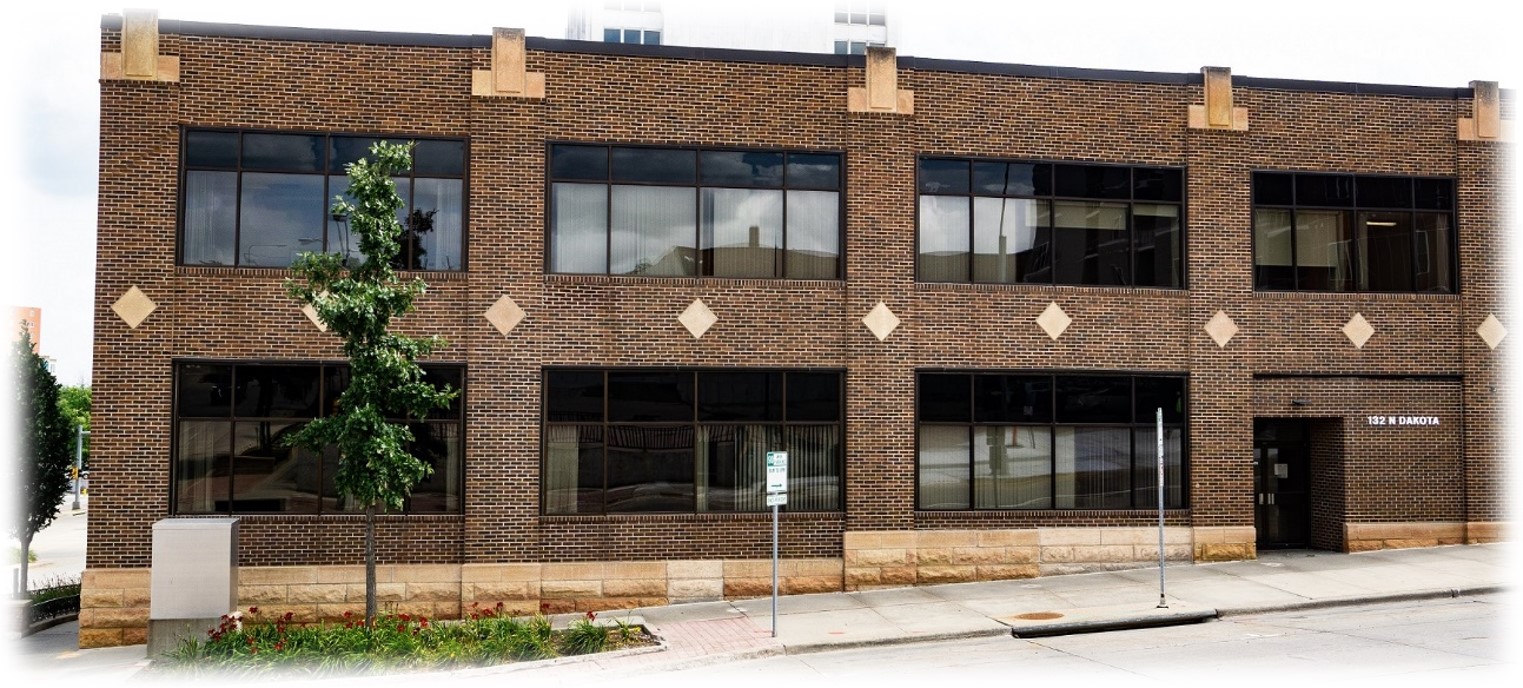 Brown brick building with front sidewalk.